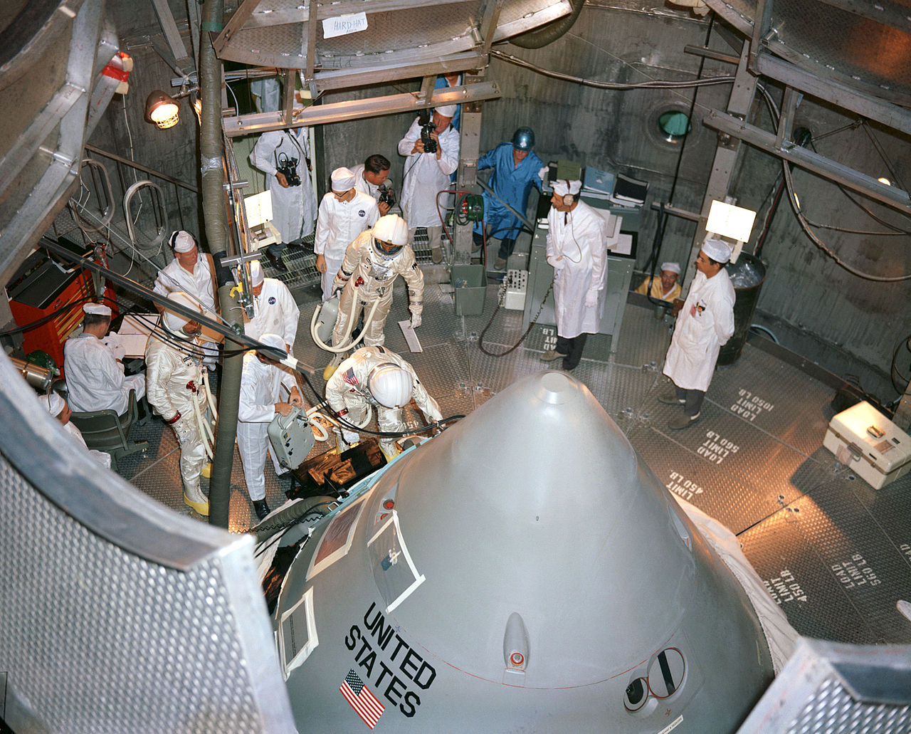 1280px-Apollo_1_crew_prepare_to_enter_their_spacecraft_in_the_altitude_chamber_at_Kennedy_Spac...jpg