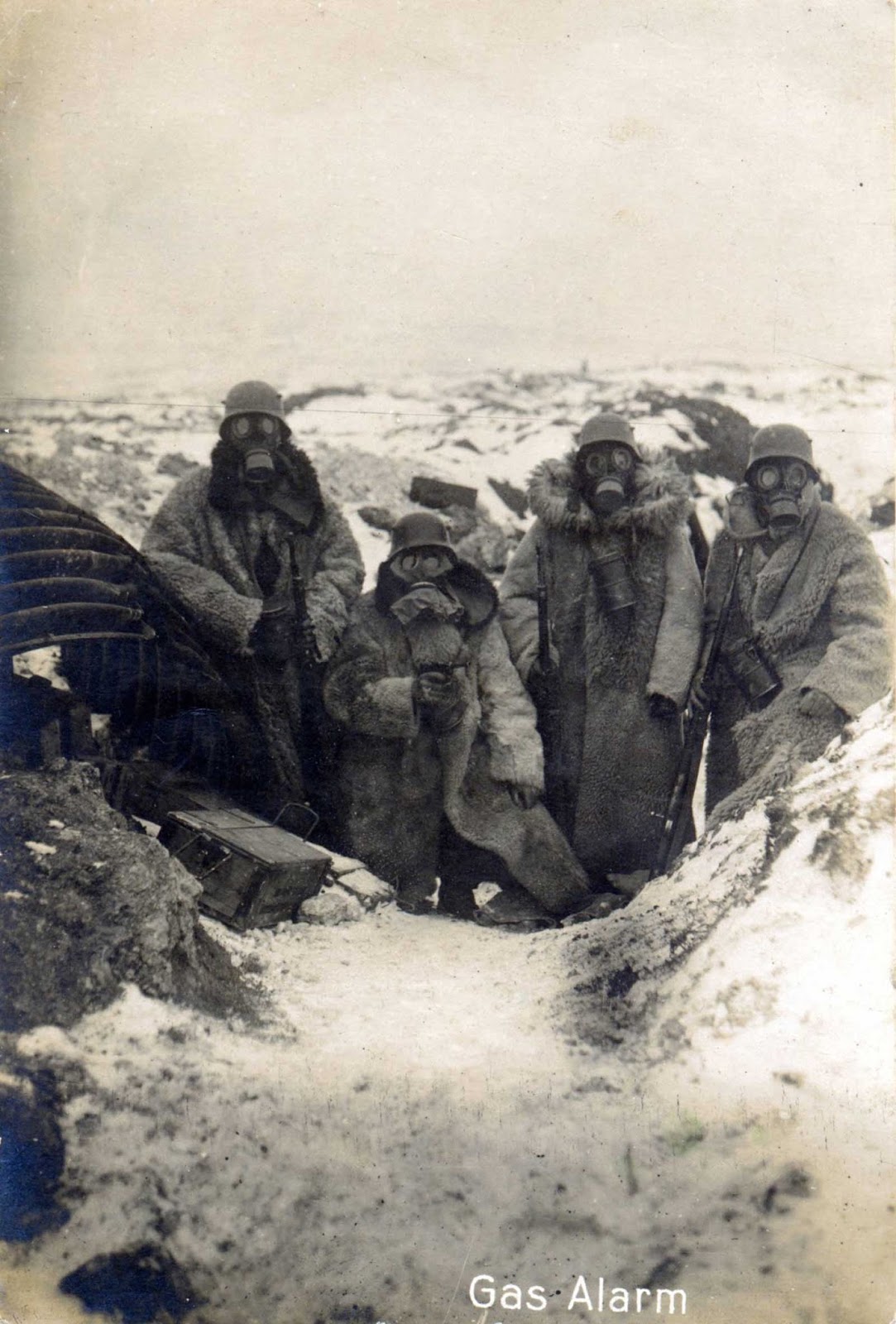 Four-German-soldiers-wearing-fur-coats-and-gas-masks-in-a-trench-1917.jpg